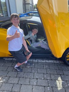 Children sitting in a McLaren Supercar at the Isle Of Man with Waynes World Of Wheels