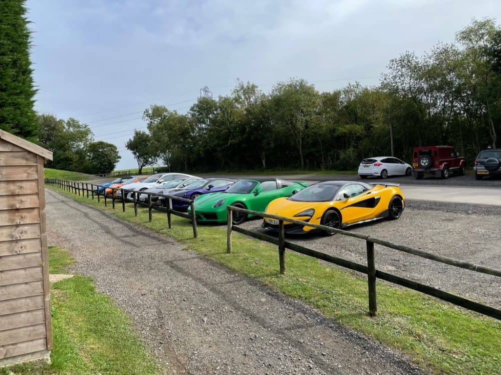 a number of supercars parked in a row in The Cotswolds while on a Waynes World Of Wheels Super car drive