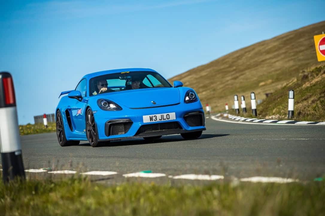 Shark blue Porsche GT4 driving the open roads of The Isle Of Man with WWOW Supercar Club